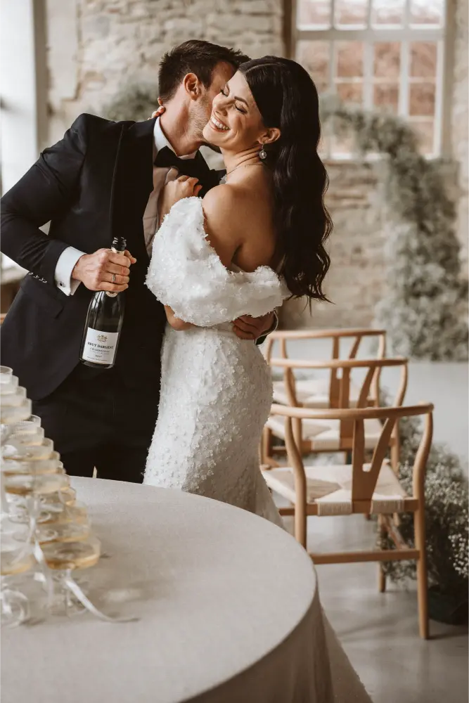 Gut Ostenwalde Hochzeit Champagner tower Bräutigam küsst am Hals