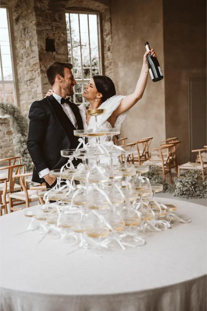Gut Ostenwalde Hochzeit Champagner tower Braut hält flasche hoch