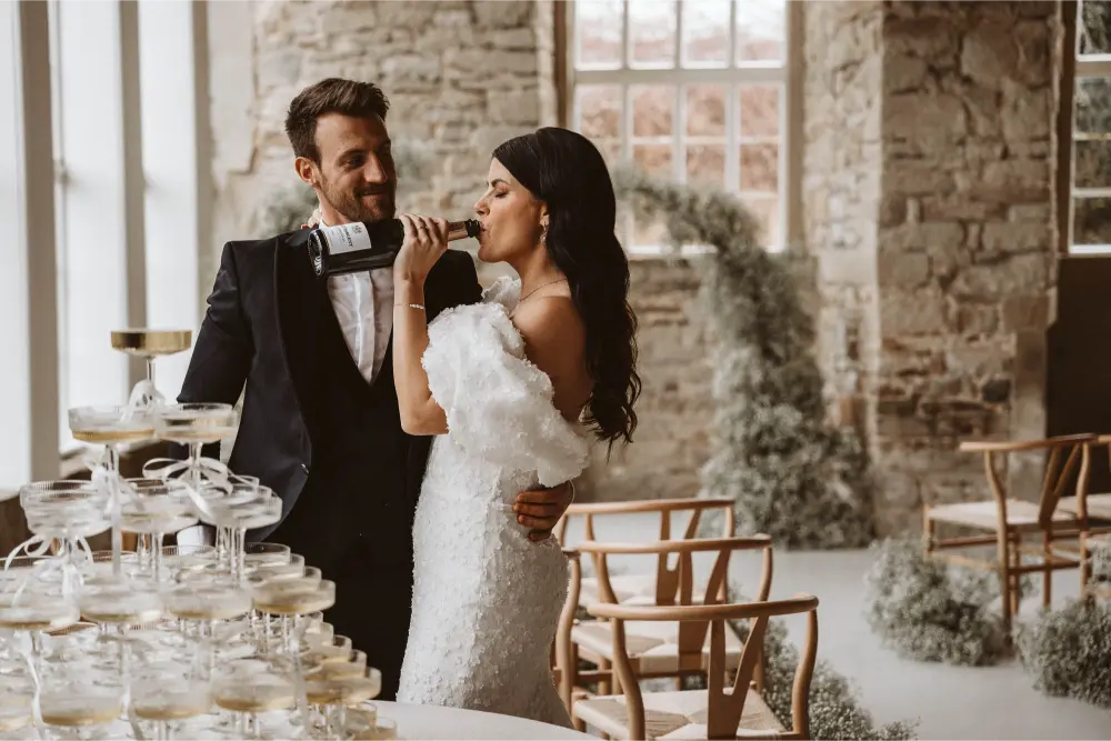 Gut Ostenwalde Hochzeit Champagner tower Braut trinkt aus Flasche