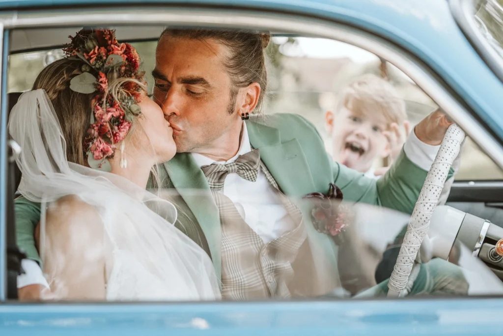 Hochzeitsfotograf Münster Brautpaar im Auto mit Kind