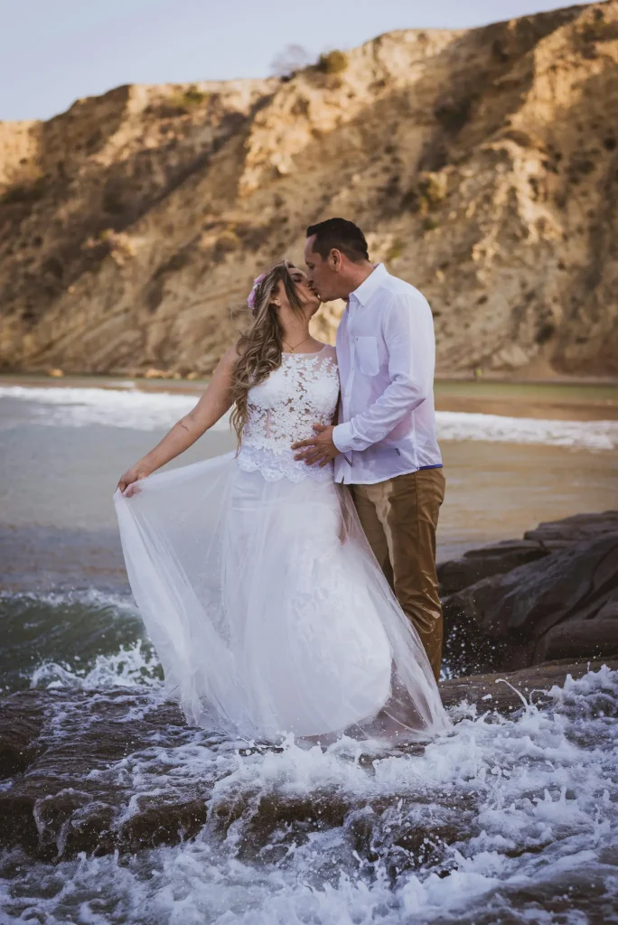 Hochzeitsfotograf Mallorca Brautpaar küssend in Wellen