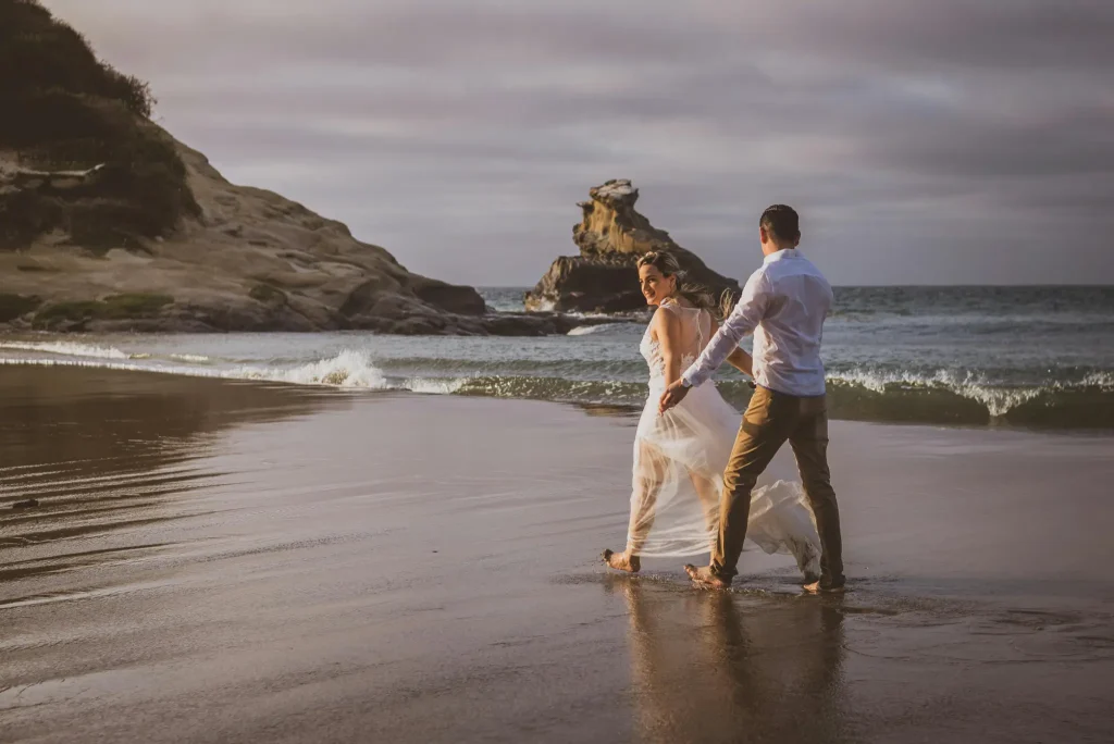 Hochzeitsfotograf Mallorca Brautpaar laufen Wellen im Hintergrund