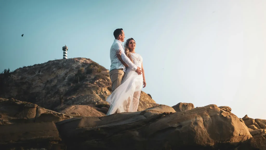 Hochzeitsfotograf Mallorca Paar vor Leuchtturm schaut in die Ferne